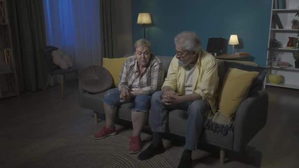 Toma Una Pareja Ancianos Está Sentada Sofá Discutiendo Mujer Está — Vídeo de stock