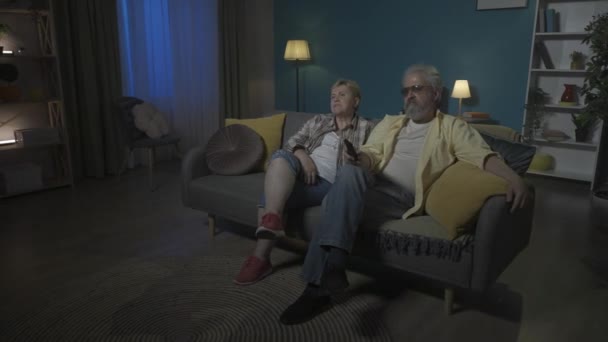 Shot Elderly Couple Sitting Sofa Apartment Look Side Watch Movie — Stock Video