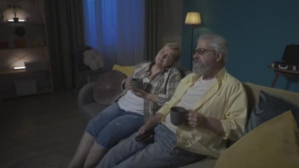 Filmen Visar Ett Äldre Par Som Sitter Soffa Och Dricker — Stockvideo