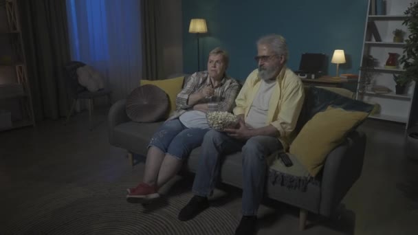 Starsza Para Ogląda Horror Telewizji Popcorn Obserwują Uważnie Skoncentrowani Materiały — Wideo stockowe