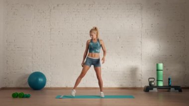 Evde kişisel spor eğitimleri. Spor giyimli bir kadın spor yapıyor. Sağlık ve sağlık reklamları konsepti. Atletik kadın jimnastik koçu çevrimiçi dersler için bacak bacak üstüne atıyor..