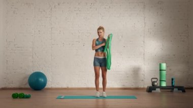 Evde kişisel spor eğitimleri. Spor giyimli bir kadın spor yapıyor. Sağlık ve sağlık reklamları konsepti. Atletik kadın fitness koçu çevrimiçi dersler için lastik bant bisepsi kaldırıyor..