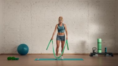Evde kişisel spor eğitimleri. Spor giyimli bir kadın spor yapıyor. Sağlık ve sağlık reklamları konsepti. Atletik kadın fitness koçu çevrimiçi dersler için triceps lastik kaldırma yapıyor..