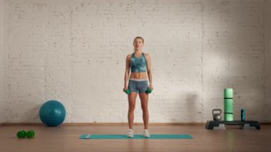 Evde kişisel spor eğitimleri. Spor giyimli bir kadın spor yapıyor. Sağlık ve sağlık reklamları konsepti. Atletik kadın jimnastik koçu yarım yamalak kollarını sallıyor..