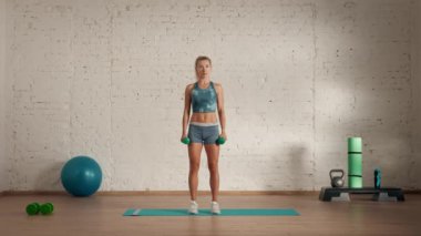 Evde kişisel spor eğitimleri. Spor giyimli bir kadın spor yapıyor. Sağlık ve sağlık reklamları konsepti. Atletik kadın jimnastik koçu yan teknik olarak kol sallaması yapıyor..
