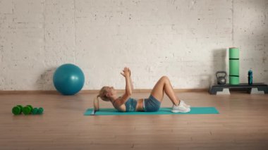 Evde kişisel spor eğitimleri. Spor giyimli bir kadın spor yapıyor. Sağlık ve sağlık reklamları konsepti. Atletik kadın fitness koçu dersler için karın kaslarını açıklıyor..