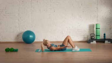 Evde kişisel spor eğitimleri. Spor giyimli bir kadın spor yapıyor. Sağlık ve sağlık reklamları konsepti. Atletik kadın fitness koçu çevrimiçi dersler için vücut eğikliği egzersizi yapıyor..