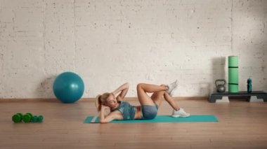 Evde kişisel spor eğitimleri. Spor giyimli bir kadın spor yapıyor. Sağlık ve sağlık reklamları konsepti. Atletik kadın spor koçu çevrimiçi dersler için karın kası egzersizi yapıyor..