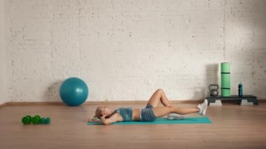 Evde kişisel spor eğitimleri. Spor giyimli bir kadın spor yapıyor. Sağlık ve sağlık reklamları konsepti. Atletik kadın fitness koçu çapraz değişiklik yapıyor. Ders için el egzersizi yapıyor..