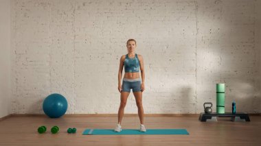 Evde online olarak kişisel spor dersleri. Spor giyim bölümünde egzersiz yapan sarışın bir kadın. Sağlık hizmetleri yaratıcı reklam konsepti. Kadın fitness koçu başlamaya hazır, kameraya bakıyor..