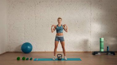 Evde online olarak kişisel spor dersleri. Spor giyim bölümünde egzersiz yapan sarışın bir kadın. Sağlık hizmetleri yaratıcı reklam konsepti. Kadın fitness koçu odada el ele tutuşup gülümsüyor..