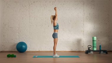 Evde online olarak kişisel spor dersleri. Spor giyim bölümünde egzersiz yapan sarışın bir kadın. Sağlık hizmetleri yaratıcı reklam konsepti. Kadın fitness koçu salonda, dambılı kaldırdı..