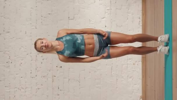 个人在线运动训练在家里 穿着运动服的漂亮女性在做运动 卫生保健和福利广告概念 女子健身教练分三步跳 垂直录像 — 图库视频影像