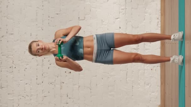 个人在线运动训练在家里 穿着运动服的漂亮女性在做运动 卫生保健和福利广告概念 女健身教练做哑铃三头肌设置 垂直录像 — 图库视频影像
