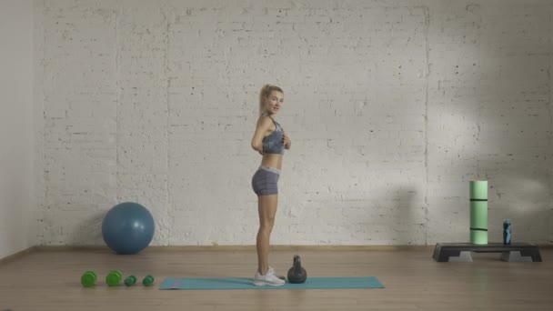 个人运动训练在家里 穿着运动服的女性做运动 保健和健康广告概念 田径女子健身教练做背弯与水壶 Hdr — 图库视频影像