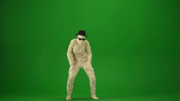 裹着绷带的可怕的木乃伊戴着黑色的帽子和太阳镜跳舞 绿色屏幕 为你的促销短片或广告提供工作空间 全身而退万圣节假期 — 图库视频影像