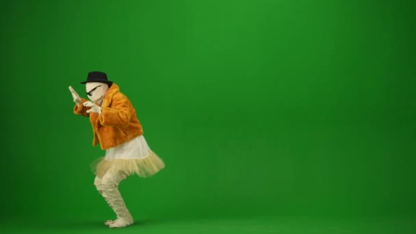 绿色屏风隔离的彩色关键视频捕捉了一个迷人的木乃伊在橙色的毛皮外套 帽子和太阳镜跳舞 为你的促销短片或广告提供工作空间 万圣节假期 — 图库视频影像