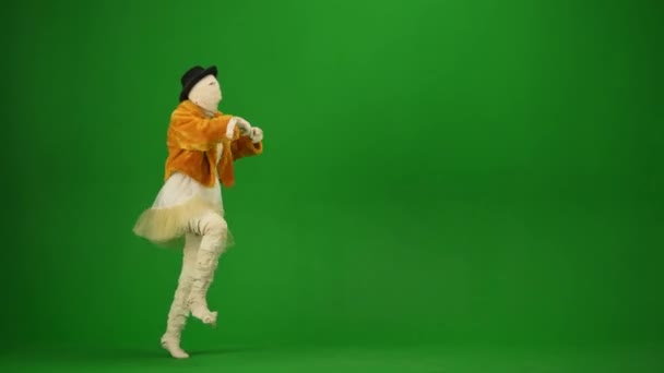 オレンジ色のコート サングラスのグラマーなミイラは手と足を振って踊ります 緑のスクリーンはクロマ キーを隔離しました モックアップ ワークスペース 全長について ハロウィーンの休日 — ストック動画