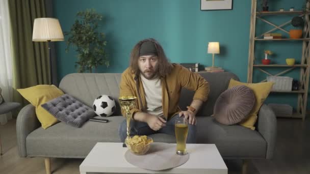 Marco Hombre Está Sentado Sofá Patatas Fritas Cerveza Una Taza — Vídeo de stock
