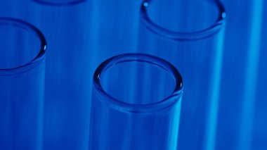 Laboratuvardaki neon mavi ışık test tüplerini kapatın. Bilimsel deney, araştırma, çalışma. Laboratuvar cam takımının detaylı görüntüsü. Yaratıcı içerik veya tıbbi reklam.