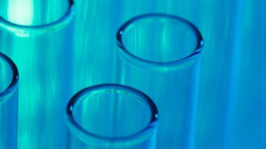 Laboratuvardaki neon mavi ışık test tüplerini kapatın. Bilimsel deney, araştırma, çalışma. Laboratuvar cam takımının detaylı görüntüsü. Yaratıcı içerik veya tıbbi reklam.