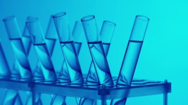 Laboratuvarda fuild ile doldurulmuş mavi ışık test tüplerini kapatın. Bilimsel deney, araştırma, çalışma. Laboratuvar cam takımının detaylı görüntüsü. Yaratıcı içerik veya tıbbi reklam.