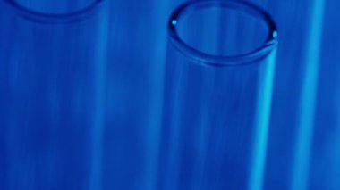 Laboratuvardaki mavi ışık test tüplerini kapatın. Bilimsel deney, araştırma, çalışma. Laboratuvar cam takımının detaylı görüntüsü. Yaratıcı içerik veya tıbbi reklam.