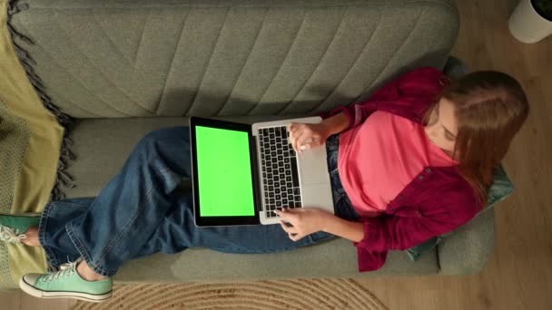 Вид Сверху Запечатлевающий Молодую Женщину Лежащую Диване Смотрящую Экран Ноутбука — стоковое видео