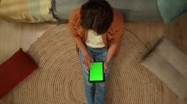 Üst görüntüde yerde oturan genç bir adam var. Reklam alanı olan tablet ekrana bakıyor. Çalışma alanı onu taklit ediyor. Boş zaman, online alışveriş, sosyal ağlar ve iletişim.
