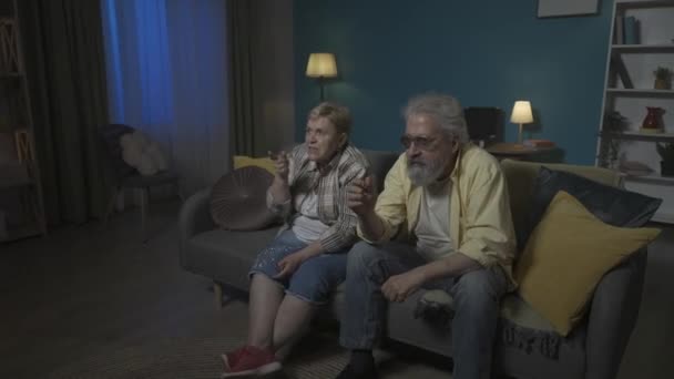 Odada Bir Koltukta Oturan Yaşlı Çift Dikkatle Bir Yere Bakıyor — Stok video