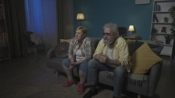年配のカップルが部屋のソファーに座り どこかをじっと見つめていた 彼らは興奮し 何かを待っている すると彼らは怒り Hdr Bt2020 Hlg材料について — ストック動画