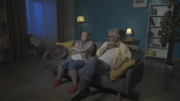 Elderly Couple Sitting Couch Room Staring Intently Somewhere Both Tired — Stock Video