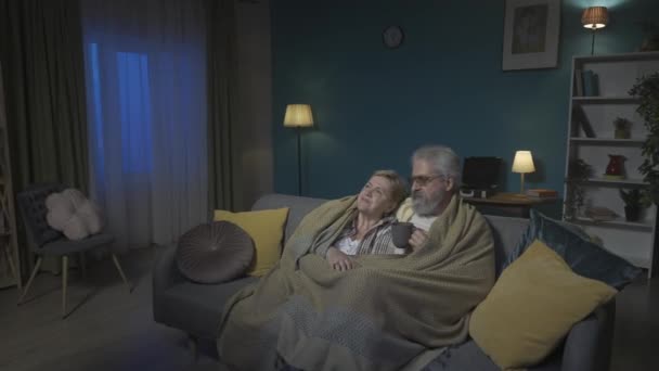 Footage Shows Elderly Couple Sitting Couch Plaid Watching Movie Show — Stock Video