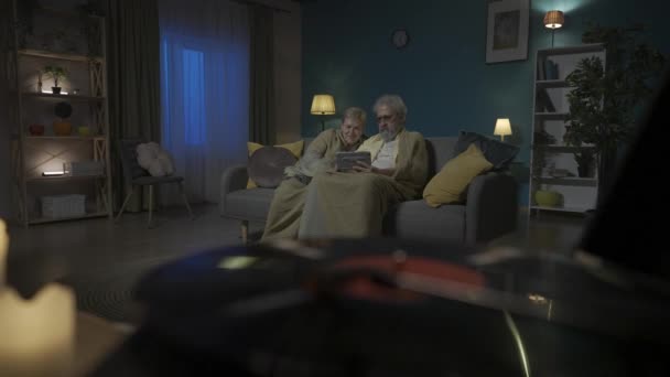 近距离拍摄显示了一个有乙烯唱片的乙烯唱片播放器 在背景下 一对老夫妇坐在沙发上 带着平板电脑看网站 中等视频 Hdr Bt2020 Hlg Material — 图库视频影像