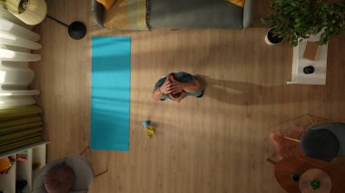 Manzara, sabah egzersizini yapan genç bir adamı pencerenin önünde çömelirken yakalıyor. Ev, oda, ev içi aktiviteler. Sağlıklı ve aktif yaşam tarzı, sabah rutini, hedeflere ulaşmak..