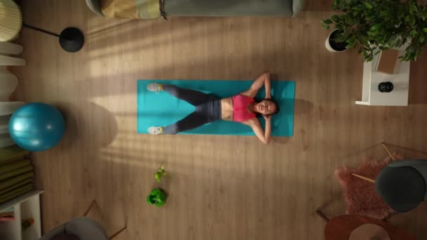 头像拍摄一个年轻女子做晨练 腹肌在窗前锻炼 室内活动 健康和积极的生活方式 晨间例行公事 实现目标 — 图库视频影像