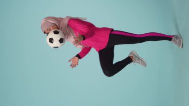 Tam ölçekli izole bir video, spor giyimli ve tesettürlü çekici bir genç kadın, Sheila. O, diziyle topa vuruyor. Reklamınız için yer, modellik, promosyon, spor