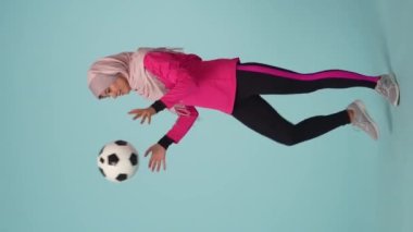 Tam ölçekli izole bir video, spor giyimli ve tesettürlü çekici bir genç kadın, Sheila. O, diziyle topa vuruyor. Reklamınız için yer, modellik, promosyon, spor