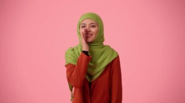 Orta ölçekli izole bir video, tesettür ve duvak takan çekici bir genç kadını çekiyor. Sinsi, sinsi, ağzını kapayan, bir sır veren birine benziyor. Reklamınıza, kültürünüze, çeşitliliğinize yer.