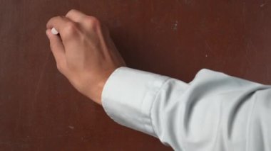 Kalıplı kahverengi karatahta arka planı. Erkek el yazısı A, B, C, tahtaya alfabenin ilk harfleri yakın çekimde beyaz tebeşirle. Eğitici ve yaratıcı içerik, okul kavramı.