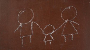 Kalıplı kahverengi karatahta arka planı. Bir ailenin çocuk çizimi tahtaya beyaz tebeşirle çizilir. Kapatın. Eğitici ve yaratıcı içerik, okul kavramı.