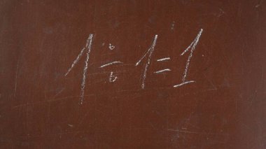 Kalıplı kahverengi karatahta arka planı. Bölme denklemi tahtaya beyaz tebeşirle yazılmış. Yakın çekim. Eğitici ve yaratıcı içerik, okul kavramı.