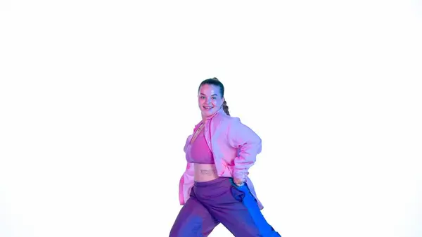スタジオで白い隔離された背景でジャズファンクを踊る魅力的な女性 ブルーとピンクのスポットライト エネルギッシュなダンス振付 ミディアムフル クリエイティブコンテンツ プロモーションクリップ — ストック写真