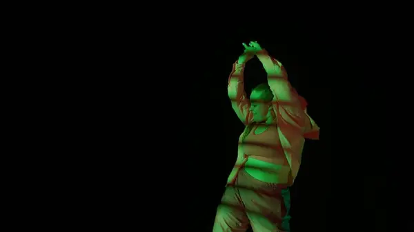 スタジオで黒い隔離された背景でジャズ ファンクを踊る魅力的な女性 緑色のスポットライト ストライプ落下影エネルギッシュダンス振付 クリエイティブコンテンツ プロモーションクリップ — ストック写真