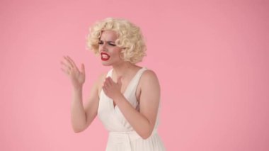 Saldırgan bir kadın bağırıyor, küfrediyor, birini suçluyor stüdyoda pembe arka planda onu işaret ediyor. Marilyn Monroe 'ya benzeyen kadın nefes veriyor, kendini toparlıyor, saçını düzeltiyor ve gülümsüyor.