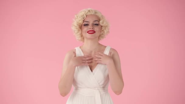 若い女性は彼女の心の底からあなたに感謝をもたらし 感謝します 白いウィッグの女性 ピンクの背景にスタジオで唇に赤い口紅の白いドレス — ストック動画