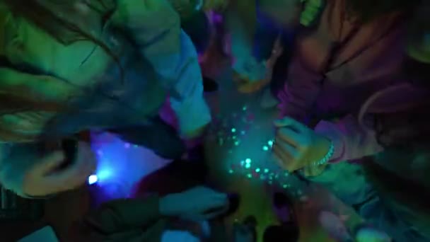 ディスコボールで飾られたパーティールームで踊るティーンエイジャーのグループ 男はDjコンソールで音楽を混ぜている ネオンライト トップビュー ズームアウト クリエイティブ — ストック動画