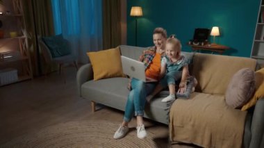 Mutlu, genç bir anne ve genç bir kız kanepede oturup videolar, dizüstü bilgisayarda çizgi filmler izliyorlar. Anne ve kızı öpüşüyor, sarılıyor, akşamları birlikte oturma odasında vakit geçiriyorlar.