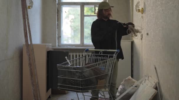 Hajléktalan Egy Elhagyatott Épület Szobájában Járkál Hasznos Dolgokat Keresve Beteszi — Stock videók