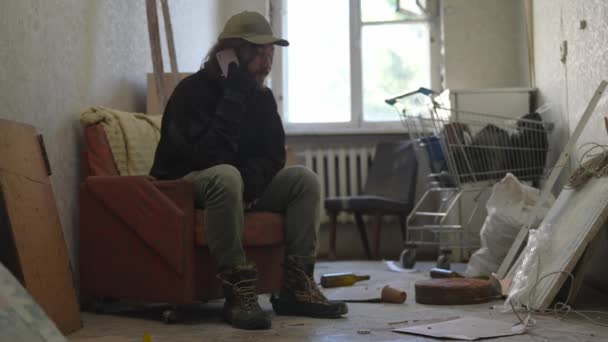 Chudák Bezdomovec Sedící Opuštěné Budově Plné Jeho Skrovných Věcí Vytočí — Stock video